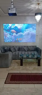 a living room with a couch and a large screen at Modern and comfortable apartment in mohammedia in Ben Yakhlef