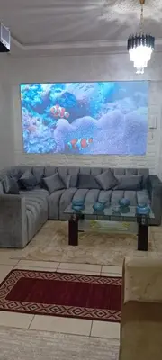 a living room with a couch and a large painting at Modern and comfortable apartment in mohammedia in Ben Yakhlef