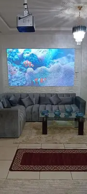 a living room with a couch and a large screen at Modern and comfortable apartment in mohammedia in Ben Yakhlef