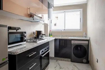 a kitchen with a washer and dryer and a microwave at TT Holidays Centro in Rabat