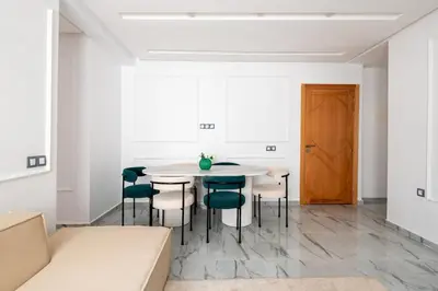 a white dining room with a table and chairs at TT Holidays Centro in Rabat