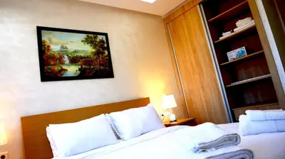 a bedroom with a bed and a painting on the wall at Beautiful and cosy apartment in Casablanca