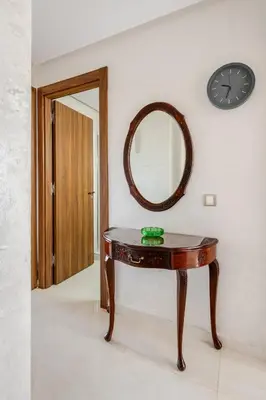 a table in a room with a mirror and a clock at Grand Appartement de standing sécurisé, proche plage avec piscine privée in Bouznika