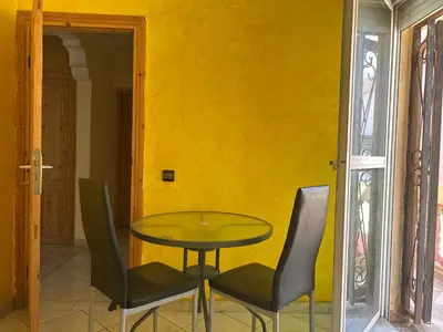 a table and chairs in a room with a yellow wall at Villa Chérine in Casablanca