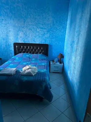 a blue bedroom with a bed and a blue wall at Villa Chérine in Casablanca