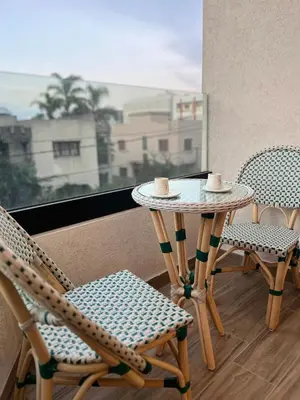 a table and chairs on a balcony with a window at Hidden Central Cozy Gem Ghandi Calm Fast WiFi Parking in Casablanca