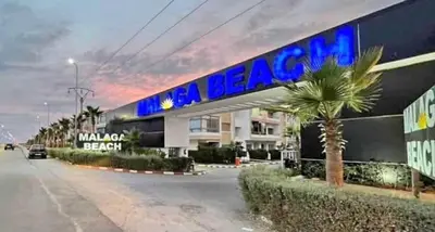 a building with a sign on the side of it at Appartement vu sur piscine à 5 minutes de la plage in Mansouria