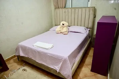 a teddy bear sitting on top of a bed at Appartement de Luxe - Piscine et Accès à la Plage in El Harhoura
