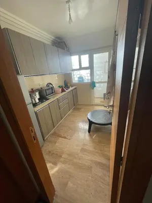 a kitchen with wooden cabinets and a chair in it at Rabat en face de océan in Rabat