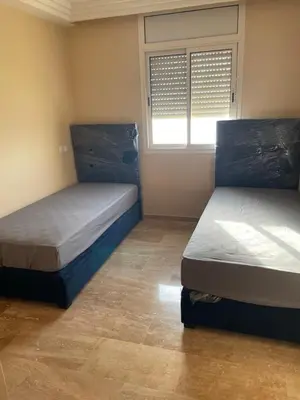 two beds in a small room with a window at Rabat en face de océan in Rabat
