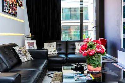a living room with a leather couch and a table with flowers at Anfa Studio Sea View in Casablanca