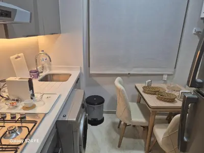 a small kitchen with a table and a sink at Aeroperla Prestige Casablanca Airport in Nouaseur