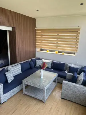 a living room with a blue couch and a table at Ocean blue by rachid in Dar Oulad Hajj Kassem