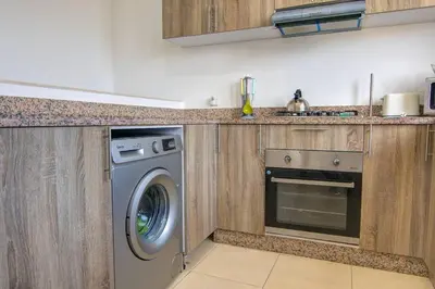 a kitchen with a washing machine and a stove at Luxury Oceanfront 3BR Villa in Rabat, Plage Val d Or - Private Beach access & Spa in Temara