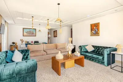 a living room with two green couches and a table at Luxury Oceanfront 3BR Villa in Rabat, Plage Val d Or - Private Beach access & Spa in Temara
