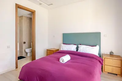 a bedroom with a large bed with a purple blanket at Luxury Oceanfront 3BR Villa in Rabat, Plage Val d Or - Private Beach access & Spa in Temara