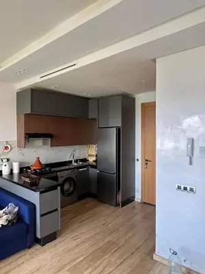 a kitchen with a refrigerator and a counter top at Relaxing Apartment Oceanic Sidi Rahal in Sidi Rahal