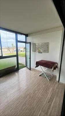 a living room with a table and a large window at Relaxing Apartment Oceanic Sidi Rahal in Sidi Rahal