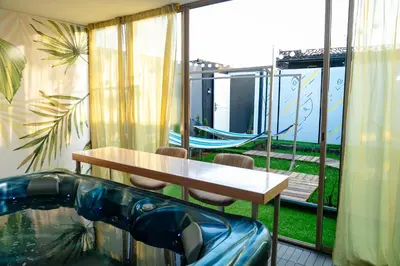 a balcony with a table and chairs and a swimming pool at Maison à Skhirat Jacuzzi, jardin & proche plage in Skhirat