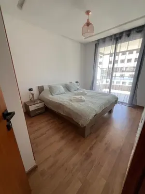 a bedroom with a bed and a wooden floor at Tour 33 CFC Studio moderne & raffiné en plein cœur de Casa in Casablanca