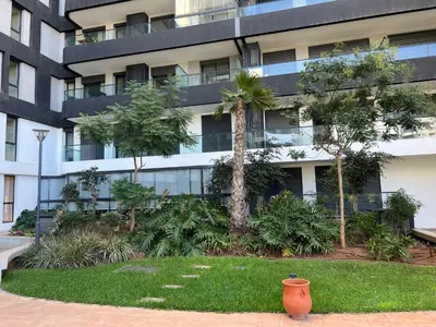 an apartment building with a garden in front of it at Tour 33 CFC Studio moderne & raffiné en plein cœur de Casa in Casablanca
