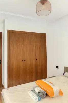 a bedroom with a bed with a wooden cabinet at Tour 33 CFC Studio moderne & raffiné en plein cœur de Casa in Casablanca
