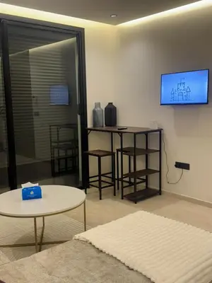 a living room with a tv and a table and chairs at Superbe T2 moderne au cœur du Maarif Confort & Style in Casablanca