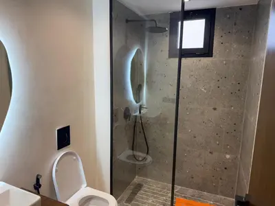 a bathroom with a glass shower with a toilet at Superbe T2 moderne au cœur du Maarif Confort & Style in Casablanca