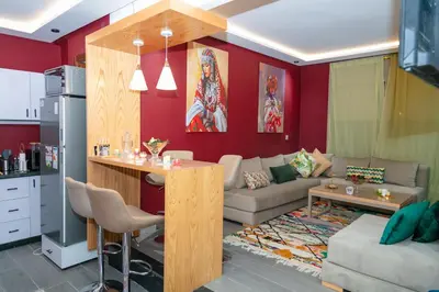 a kitchen and living room with red walls and a living room at Maison à Skhirat avec Jacuzzi et Jardin privé in Skhirat