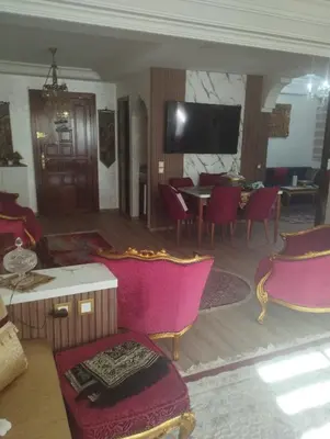 a living room with pink chairs and a tv at Lux apartment Maarif in Maarif