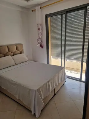 a bedroom with a bed and a large window at Sable d'or in O Ben Slimane