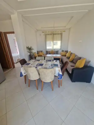 a living room with a table and a blue couch at Sable d'or in O Ben Slimane