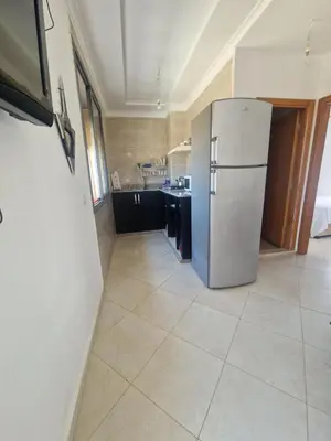a kitchen with a refrigerator and a tile floor at Sable d'or in O Ben Slimane