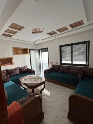 a living room with couches and a table at Résidence oasis beach mansouriah in Mohammedia