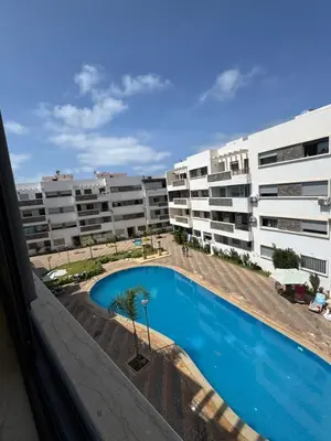 a view of a swimming pool in front of some apartment buildings at Résidence oasis beach mansouriah in Mohammedia