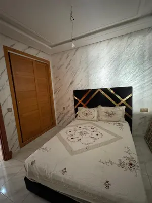 a bedroom with a bed and a wooden door at Résidence oasis beach mansouriah in Mohammedia