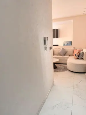 a living room with a white wall and a couch at Bright Cosy Apartment By Mohamed V Stadium in Casablanca