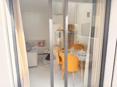 a dining room with a table and yellow chairs at Bright Cosy Apartment By Mohamed V Stadium in Casablanca