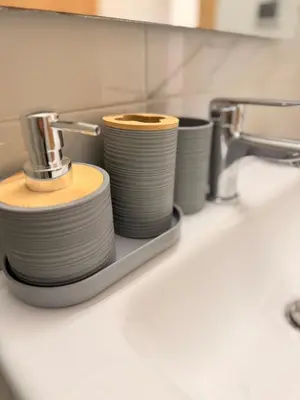 a stack of dishes sitting on a sink in a bathroom at Bright Cosy Apartment By Mohamed V Stadium in Casablanca