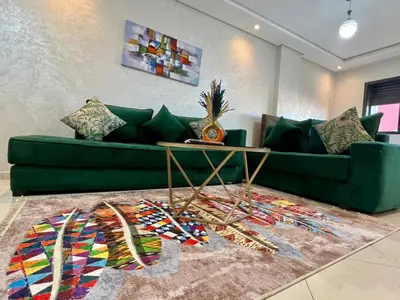 a living room with a green couch and a table at Luxury Casablanca Studio - Close to Tram in Casablanca