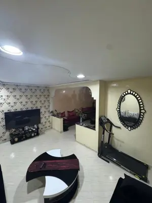 a living room with a table and a mirror at Maison kossay in Casablanca