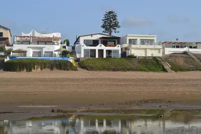 a group of houses on the beach next to a body of water at beachfront house frond de mer in Skhirat