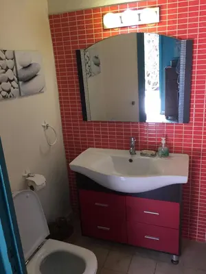 a bathroom with a sink and a mirror and a toilet at beachfront house frond de mer in Skhirat