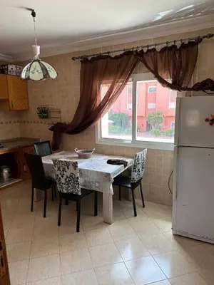 a kitchen with a table and chairs and a refrigerator at Ryad chaouia in Dar Mohammed Ould Haj Jilali
