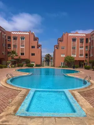 a large swimming pool in front of some buildings at Ryad chaouia in Dar Mohammed Ould Haj Jilali