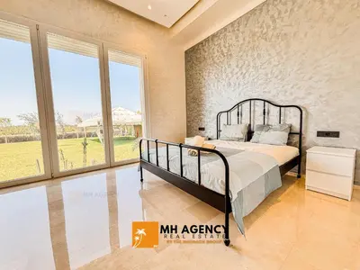 a bedroom with a bed and a large window at Oliveraie - Villa Benslimane in O Ben Slimane