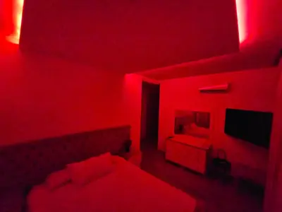 a red room with a bed and a television at Prestigia Luxury and Serenity in Rabat