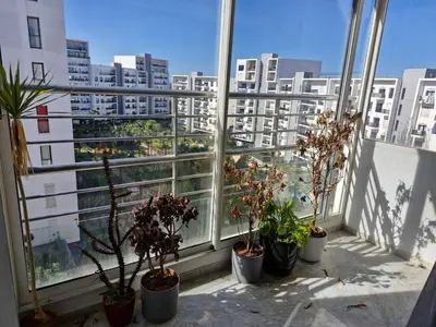 an apartment balcony with potted plants and a view of a city at Prestigia Luxury and Serenity in Rabat