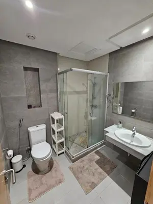 a bathroom with a shower and a toilet and a sink at Prestigia Luxury and Serenity in Rabat