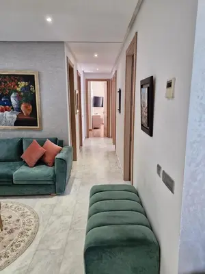 a living room with a green couch and a hallway at Prestigia Luxury and Serenity in Rabat